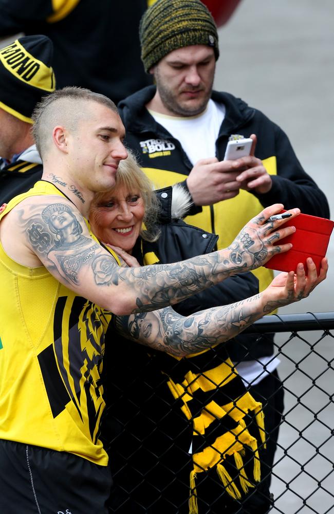 Tigers champ Dustin Martin has his photo taken with a fan after training on Friday. Picture: Ian Currie