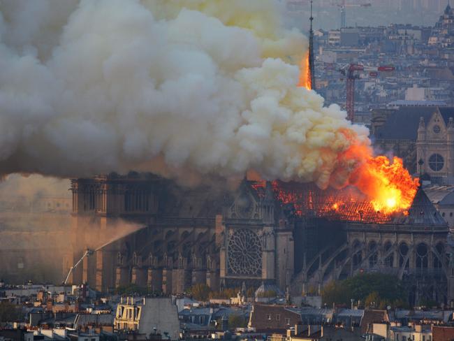 Smoke and flames rise during a fire at the landmark Notre-Dame Cathedral in central Paris on April 15, 2019, potentially involving renovation works being carried out at the site, the fire service said. (Photo by Hubert Hitier / AFP)