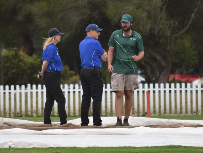 Umpires and ground staff deliberate over the pitch at Kensington Oval. Picture: Sean Teuma