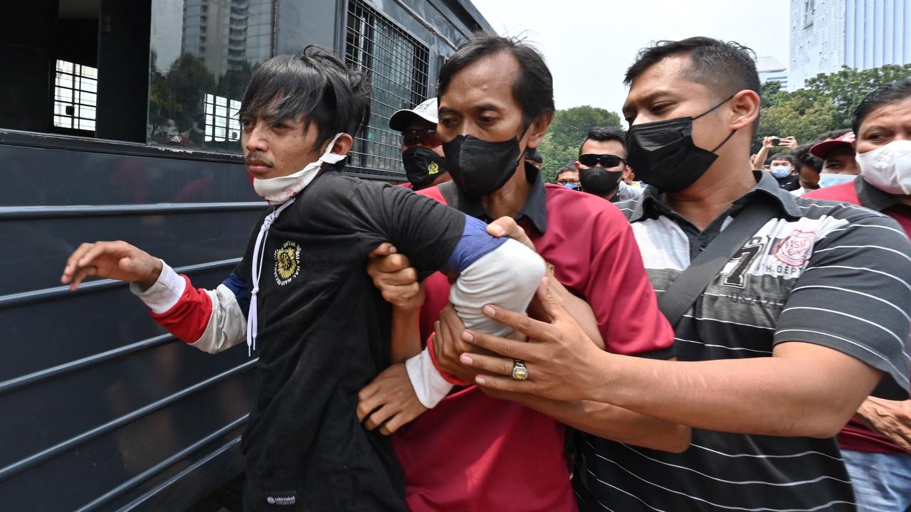 Police arrest a man during a rally against high prices of supplies in Jakarta. Picture: ADEK BERRY / AFP)