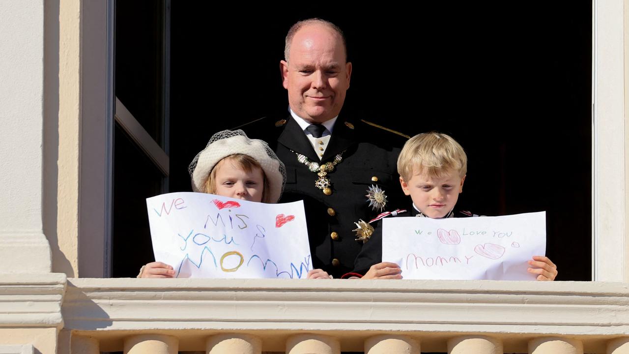 Prince Albert II of Monaco, Princess Gabriella and Prince Jacques with messages for their mother Princess Charlene at the balcony of Monaco Palace in November. Picture: Valery Hache/AFP