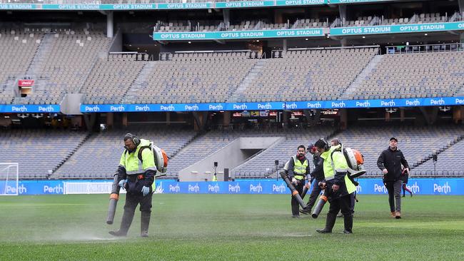 Ground staff attempt to dry the water logged pitch at Optus Stadium on July 23, 2022 in Perth, Australia. (Photo by Will Russell/Getty Images)