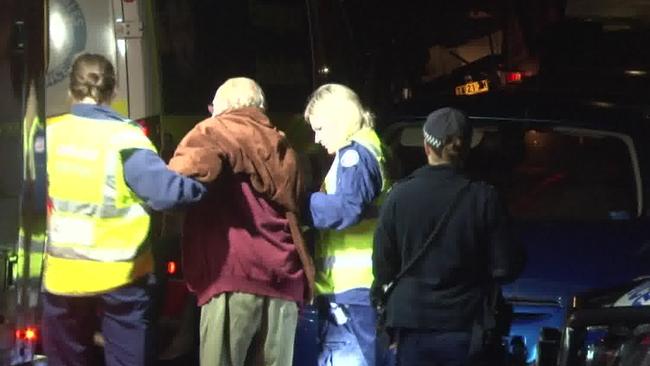 Jim Brennan being helped into an ambulance after he was found slumped on the first floor of his burning home. Picture: TNV