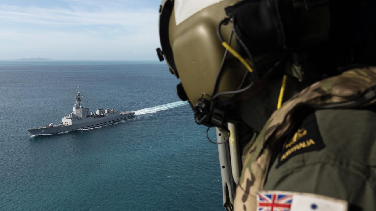 Leading Seaman Aircrewman Liam Sulley looks out towards HMAS Brisbane as the ship transits through the Prince of Wales Channel, off the coast of Queensland.