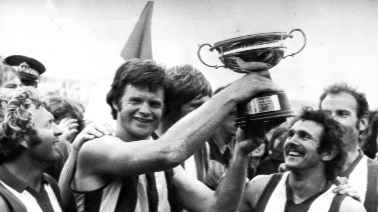 North Melbourne captain Barry Davis holds up the Australian club champions trophy the side won in Adelaide. [Sun 14/10/1975].
