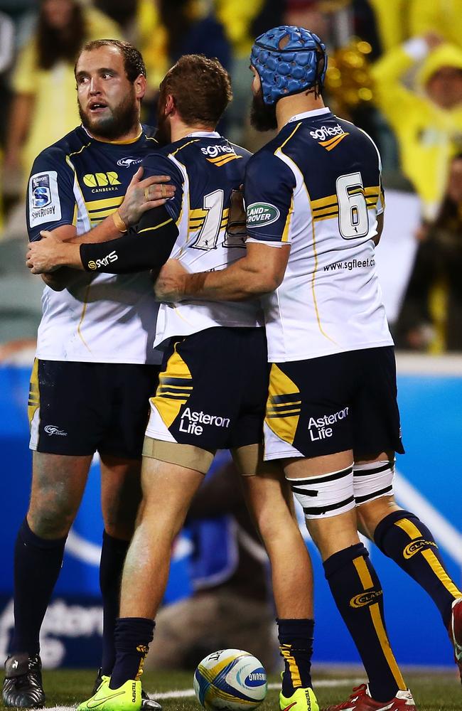 Brumbies fullback Jesse Mogg (centre) is congratulated after scoring a try.