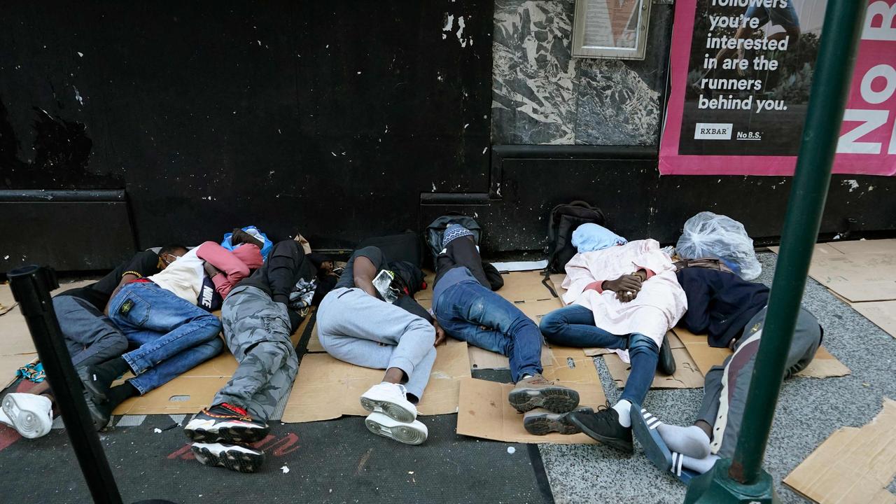 Migrants sleep outside the Roosevelt Hotel as they wait for placement at the New York hotel which has been turned into a migrant reception centre. Picture: Timothy A. Clary/AFP