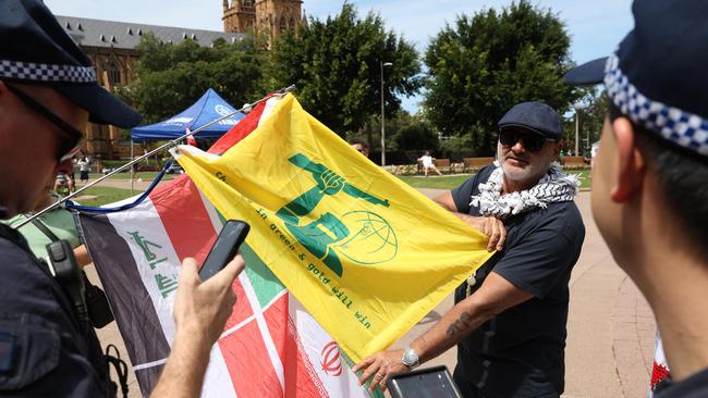 An activist shows police a “Ned Kelly” Hezbollah flag during a Sydney CBD rally in October 2024.