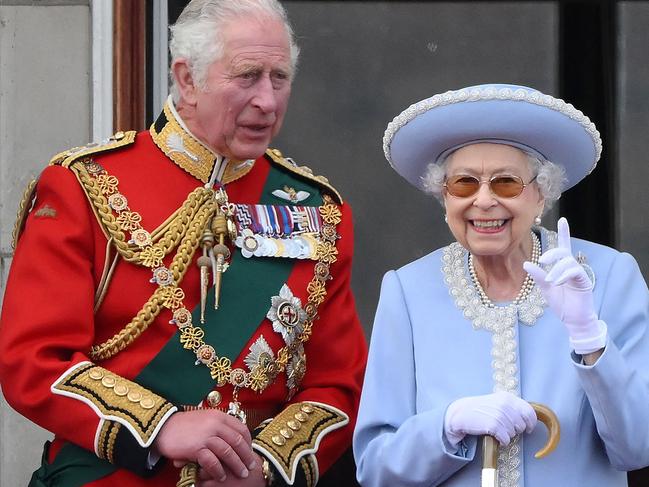 The Queen, alongside Prince Charles, smiles to the vast crowds assembled outside Buckingham Palace. Picture: AFP