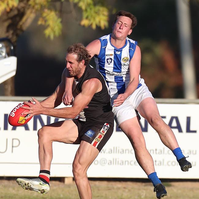Myrtleford’s Simon Curtis holds onto a mark as Corowa-Rutherglen’s Elijah Amery attempts to spoil.