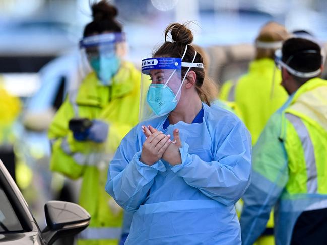 Health workers conduct COVID-19 tests at the St. Vincentâs Hospital drive-through testing clinic at Bondi Beach in Sydney June 26, 2021, on the first full day of a two-week coronavirus lockdown to contain an outbreak of the highly contagious Delta variant. (Photo by Steven Saphore / AFP)