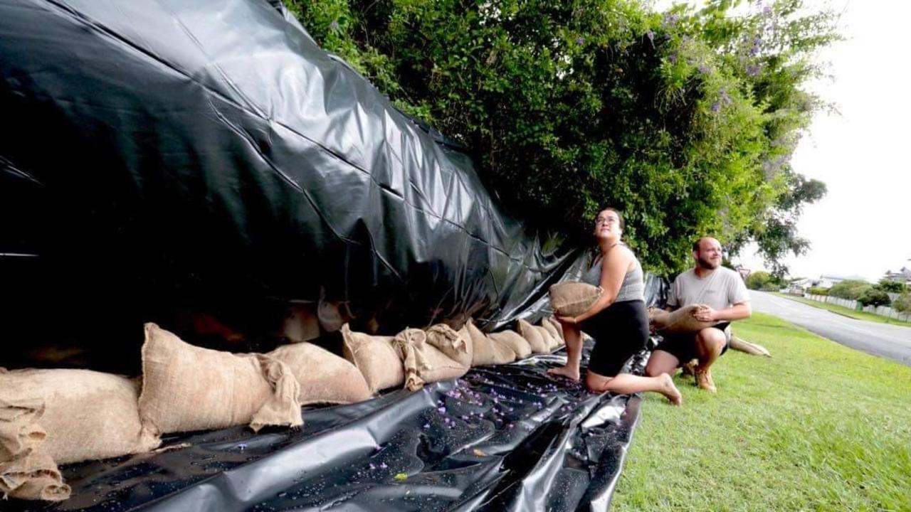 Queen St residents Courtney Azzopardi and Jay Waters construct a levee wall around their Maryborough home.