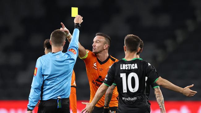 Roar skipper Tom Aldred is given a yellow card by referee Chris Beath during Brisbane’s 1-0 loss to Western United. Picture: Ryan Pierse/Getty Images