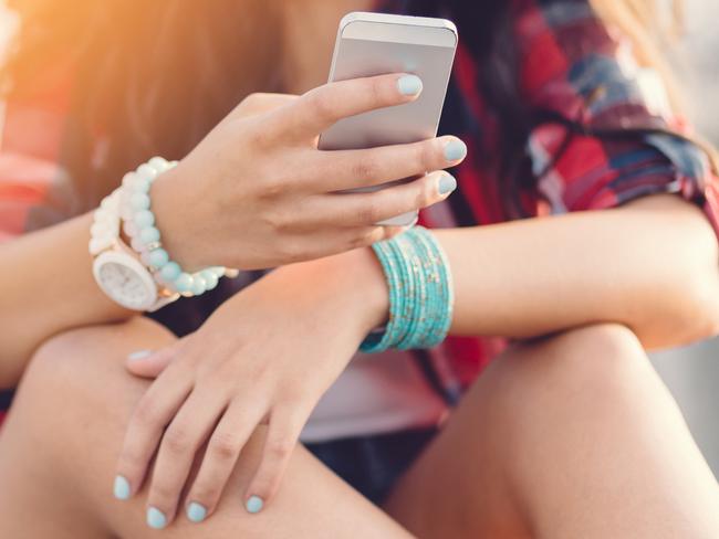 Teenage girl using smartphone at the street Photo: istock