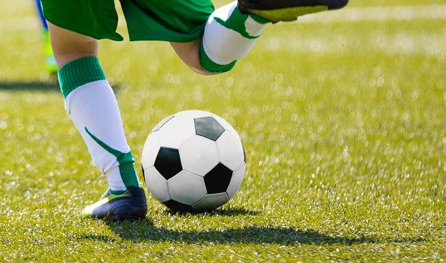 Kids Football Players Kicking Ball on Soccer Field. Sports Soccer Horizontal Background. Spectators on Stadium in the Background. Youth Junior Athletes in Red and Blue Soccer Shirts. Sports Education