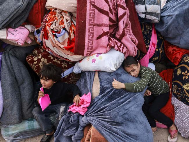 Children rest on blankets as displaced Palestinians fleeing central and southern Gaza set up tents in the new Tall el-Sultan camp west of Rafah in the southern Gaza Strip. Picture: AFP