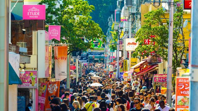 The crowded and bustling shopping street in consumerism mecca lined with stores on busy Takeshita Dori.