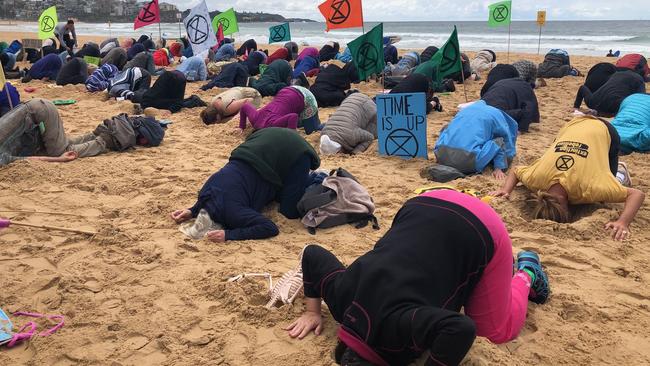 Extinction Rebellion protest at Manly last week, where activists put their heads in the sand. Picture: Julie Cross