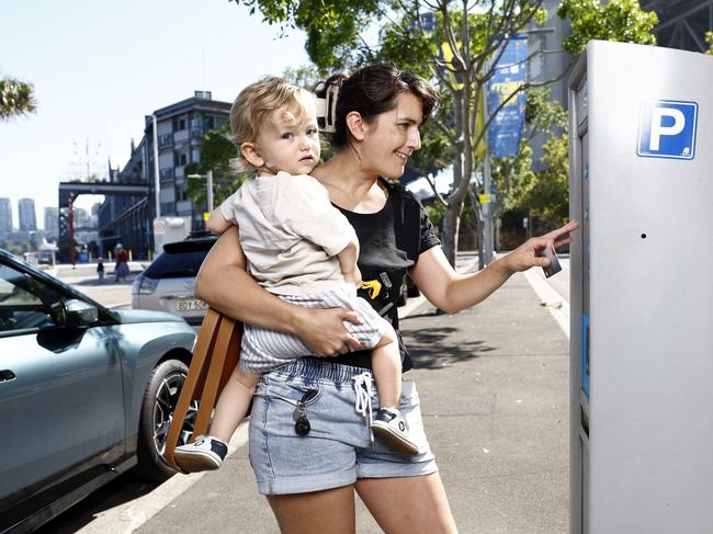 Sarah Saelens, with her son Louan, pays for parking at meter 22240 which collected around $190,000 in the last financial year. Picture: Richard Dobson