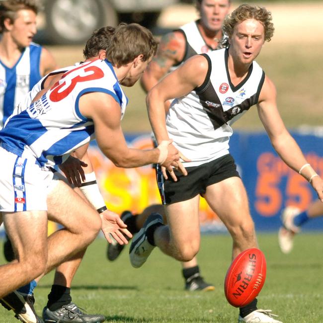 Southport Sharks versus Mt Gravatt. Southport's number 32 Brent Gorden and Mt Gravatts 23 Michael Grose run for the ball