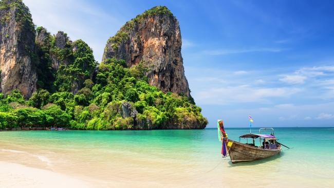 8. Railay Beach, Krabi, Thailand
Located along a small peninsula in Thailand, this beach features some impressive backdrops with its limestone cliffs towering over the shoreline. The beach itself is only accessible by boat, but is still extremely popular with travellers hoping to make it catch a glimpse of the beautiful natural setting in person.