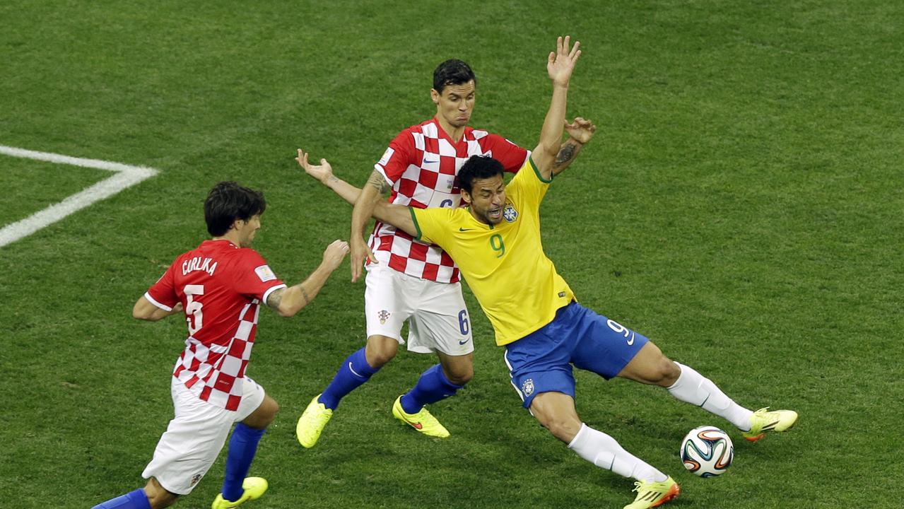 Brazil's Fred, right, falls after making contact with Croatia's Dejan Lovren during the group A World Cup soccer match between Brazil and Croatia, the opening game of the tournament, in the Itaquerao Stadium in Sao Paulo, Brazil, Thursday, June 12, 2014. At left is Croatia's Vedran Corluka. (AP Photo/Thanassis Stavrakis)