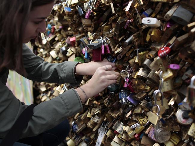 Lovestruck ... a woman a locks a padlock on the ‘Pont Notre Dame’ on May 29, 2015. Picture: AFP/Charly Triballeau