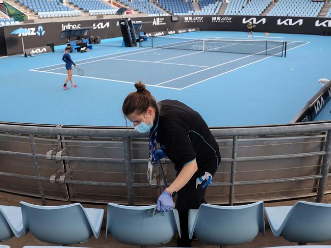 A worker cleans the seating areas on court 3 during a warm-up session at Melbourne Park on February 4, 2021. Picture: AFP