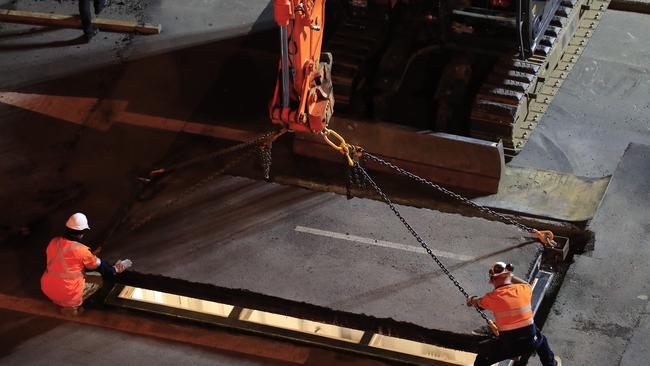 The lid is placed above artist Mike Parr as he is encased beneath Hobart's Macquarie St. Picture: AAP