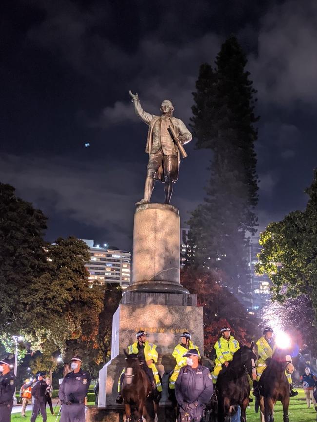 Police guard a statue of Captain James Cook. Picture: Elly Baxter