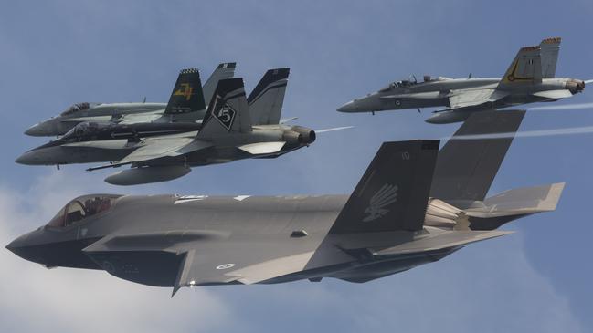 A F-35 Joint Strike Fighter (foreground) flies in formation with an F/A18 Hornets, which it is set to eventually replace.