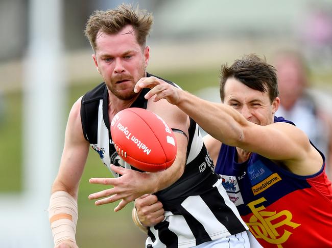 Sean Morris of Wallan handballs whilst being tackled during the round two RDFNL Bendigo Bank Seniors match between Diggers Rest and Wallan at Diggers Rest Recreation Reserve, on April 13,2024, in Diggers Rest, Australia. (Photo by Josh Chadwick)