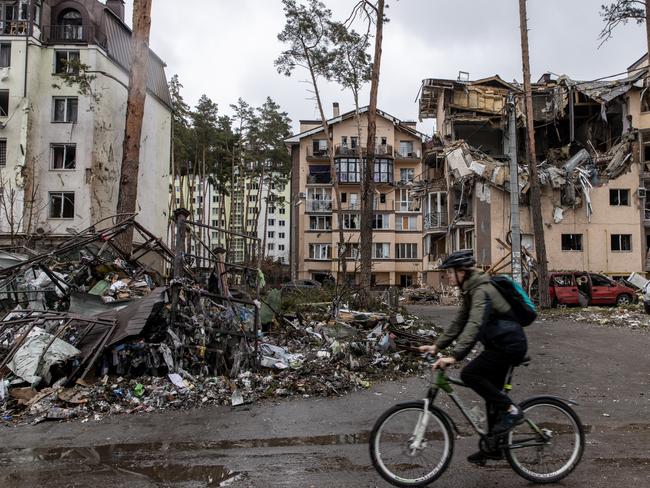 A man rides his bike past destroyed buildings in Irpin, Ukraine. Picture: Getty