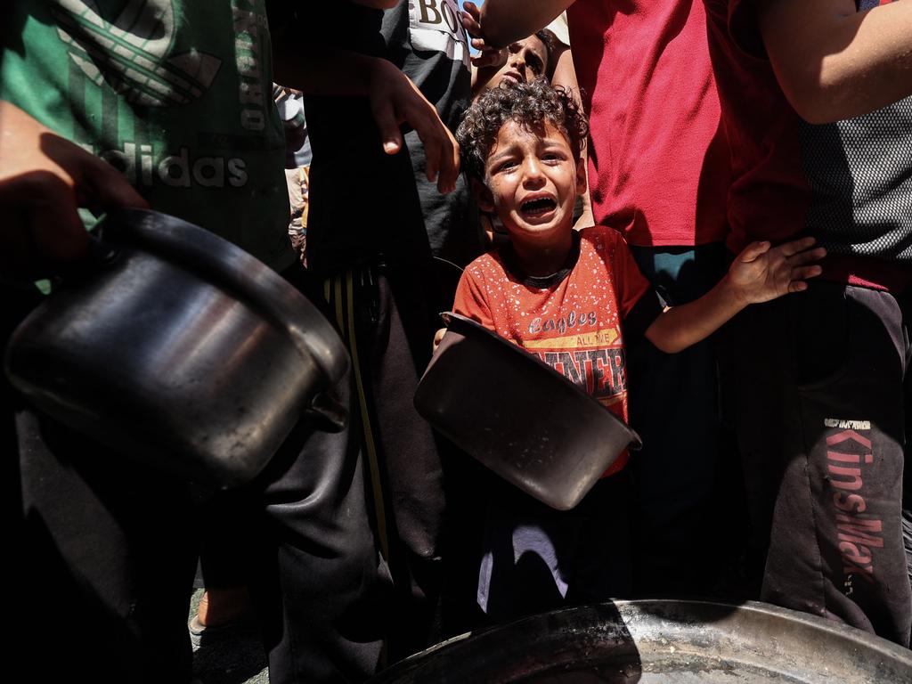 A child cries as Palestinians gather to receive a hot meal at a food distribution point in the Nuseirat camp for refugees in the central Gaza Strip on May 24, 2025. Picture: AFP