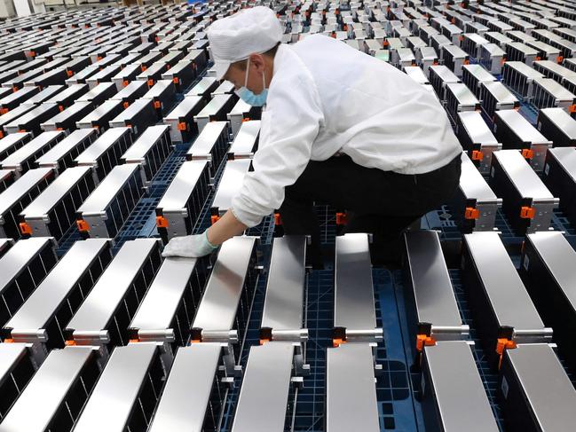 (FILES) This file photo taken on March 12, 2021 shows a worker with car batteries at a factory for Xinwangda Electric Vehicle Battery Co. Ltd, which makes lithium batteries for electric cars and other uses, in Nanjing in China's eastern Jiangsu province. - Lithium, cobalt and nickel, the metals that are essential to the manufacture of the electric batteries that will replace the combustion engines that contribute to global warming, are so sought after that Europe is preparing to open mines and refineries to try to reduce its dependence on imports. (Photo by AFP) / China OUT