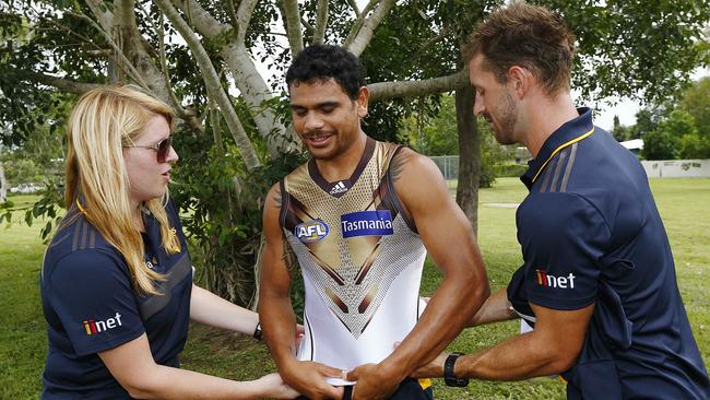 Cyril Rioli dons the new clash jumper with help from Brendan Whitecross. Picture: Wayne Ludbey