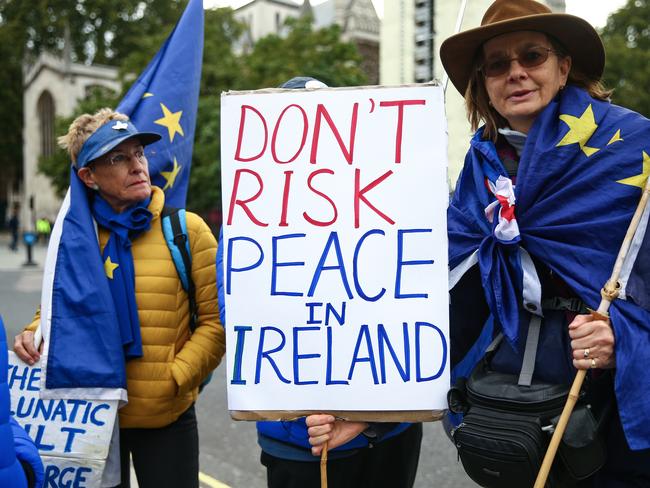 Anti-Brexit protesters hold a sign that reads “Don't Risk Peace in Ireland” outside parliament on October 3. Picture: Hollie Adams