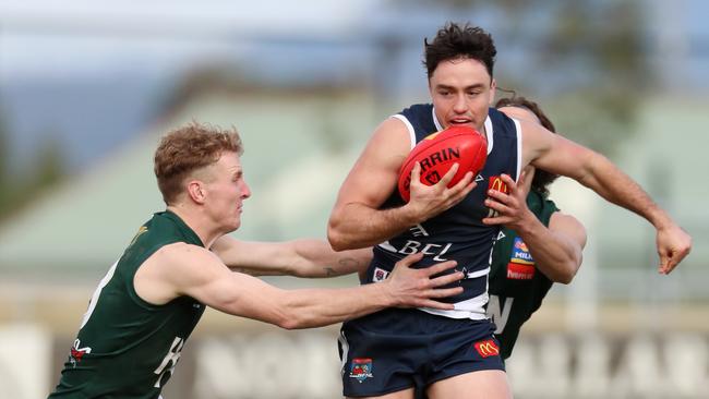 Ballarat’s Harrison Minton-Connell tries to release the ball as Hampden players tackle him. Picture Yuri Kouzmin