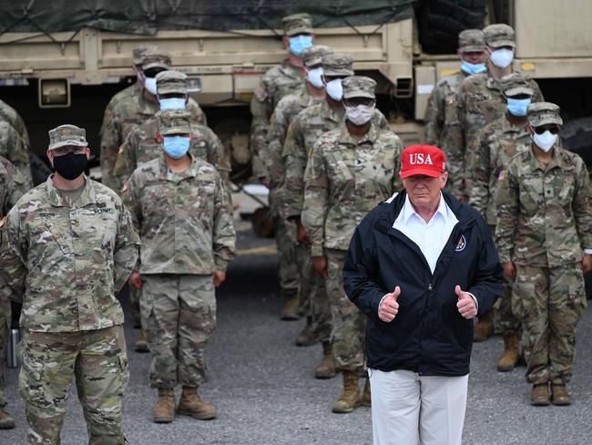 US President Donald Trump poses with National Guard troops in Lake Charles, Louisiana, on August 29, 2020. Trump surveyed damage in the area caused by Hurricane Laura. - At least 15 people were killed after Laura slammed into the southern US states of Louisiana and Texas, authorities and local media said on August 28. (Photo by ROBERTO SCHMIDT / AFP)