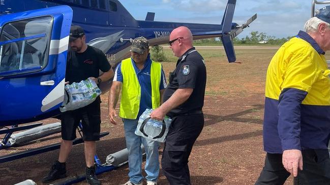 A mix of station hands, volunteers and police help unload vital supplies to residents cut-off by flooding. Nautilus Aviation Emergency Service Coordinator Tim Borresen said the company had four aircraft, four pilots and an air crewman temporarily based in the Gulf to fly in urgent supplies to flooded stations and communities. Picture: Supplied