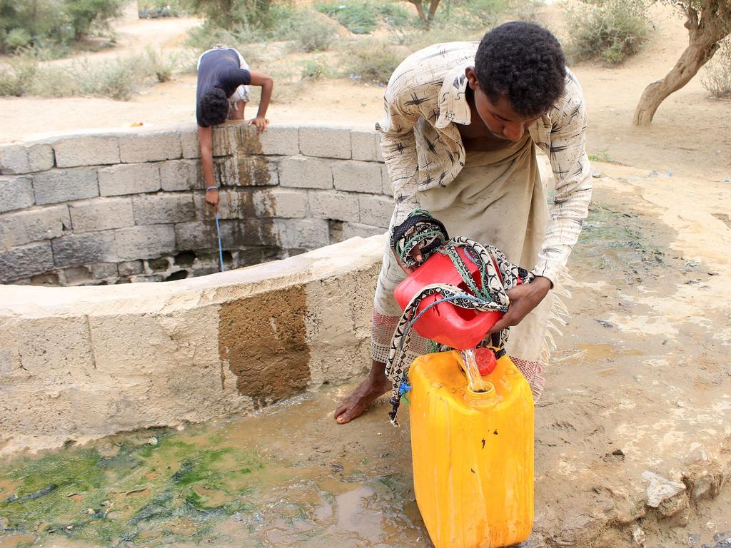 Internally displaced men in Abs in the northern Hajjah province of Yemen fill up water amid a severe heatwave and acute water shortage. (Photo by Essa AHMED / AFP)