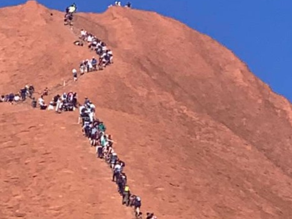 A huge line of tourists climbing up Uluru. Picture: Glenn Minett