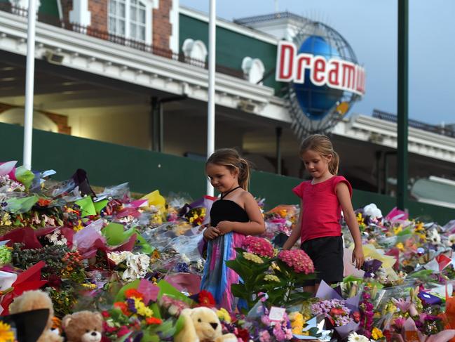 Young girls walk through a floral tribute outside the Dreamworld Theme Park on the Gold Coast, Friday, Oct. 28, 2016. (AAP Image/Dan Peled)