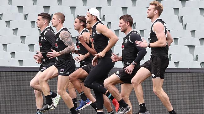 Port Adelaide’s Tom Rockliff, Hamish Hartlett, Ryan Burton, Brad Ebert warm up ahead of a Port Adelaide training session at Adelaide Oval. Picture: SARAH REED