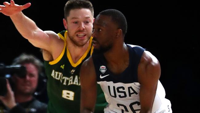 Matthew Dellavedova of the Boomers (L) guards Kemba Walker.