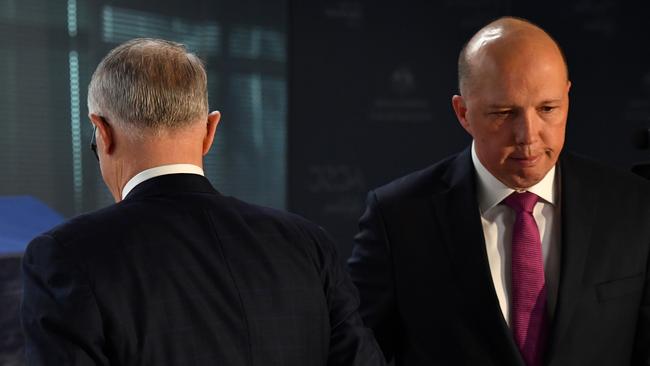 Prime Minister Malcolm Turnbull and Minister for Home Affairs Peter Dutton pass each other at the opening of the Australian Cyber Security Centre in Canberra on Thursday.