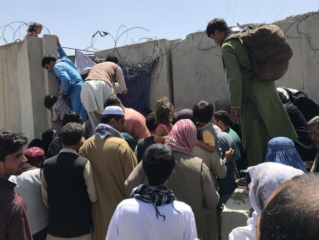 People struggle to cross the boundary wall of Hamid Karzai International Airport to flee the country after rumors that foreign countries are evacuating people even without visas, after the Taliban over run of Kabul, Afghanistan, 16 August 2021.  (Photo by STR/NurPhoto via Getty Images)