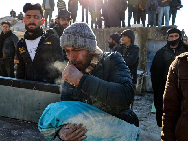 A man carries the body of his baby pulled out from the rubble in the town of Harim, in Syria. Picture: AFP