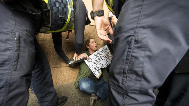 Police surround a supporter outside the Magistrates Court. Picture: Eugene Hyland