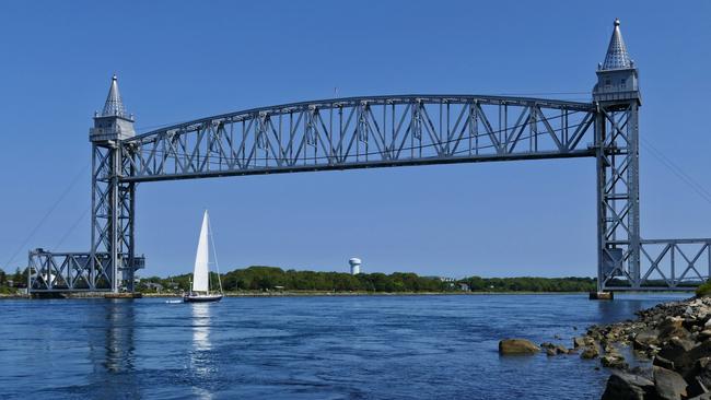 A yacht sails under the Railroad Bridge over Cape Cod Canal.